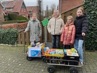 Een foto van de leerlingenraad die de opbrengst van de voedselbankinzameling kwam brengen